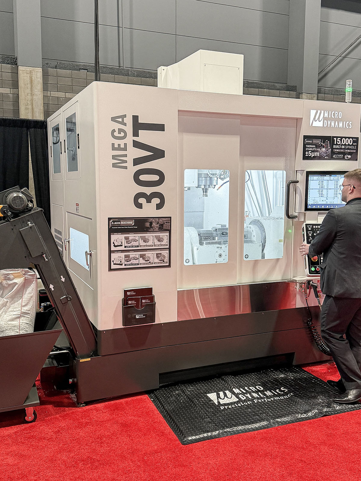 Operador no comando de um centro de usinagem Micro Dynamics MEGA 30VT durante a IMTS 2026