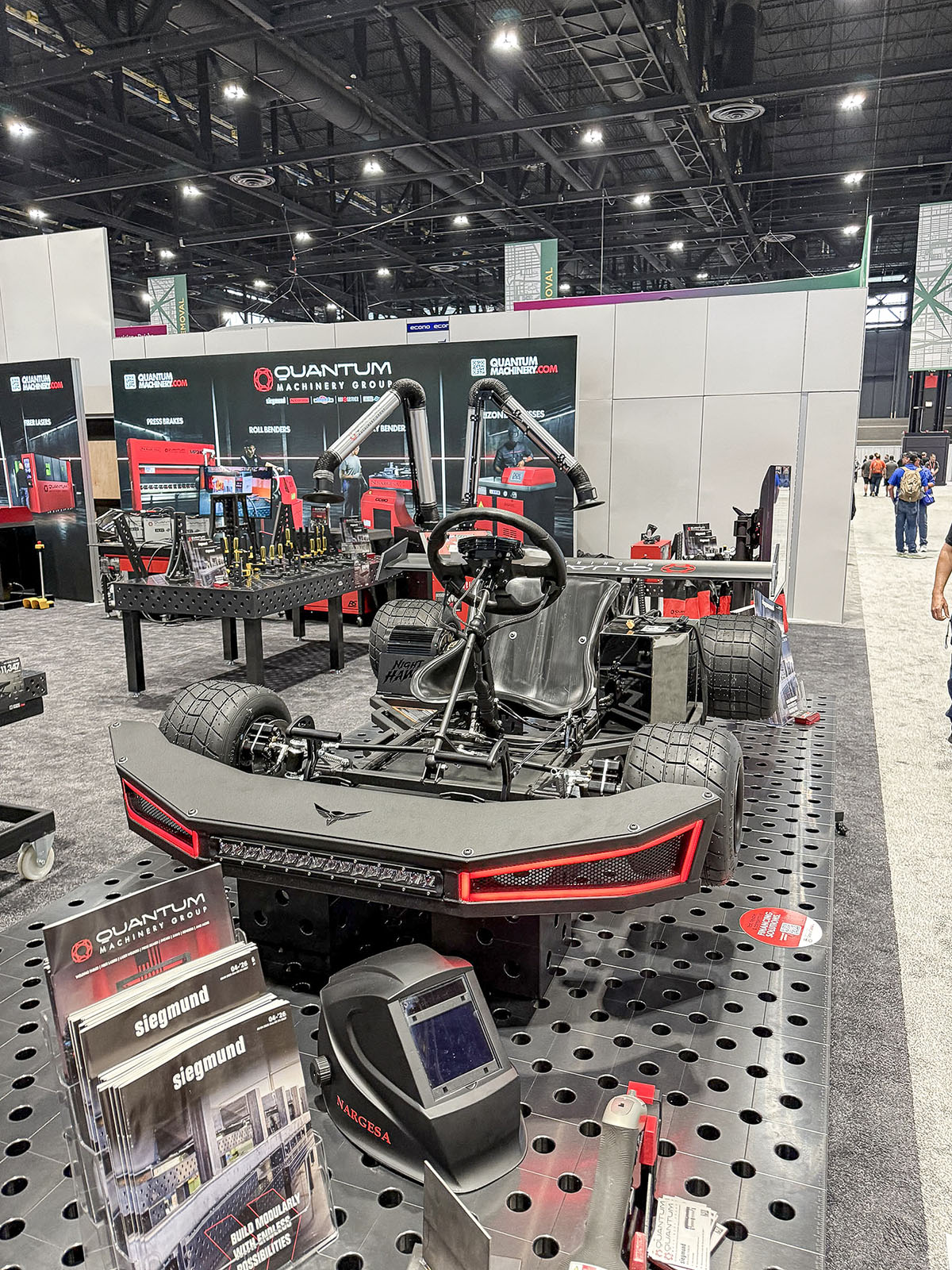 Chassi de kart fabricado exposto com equipamentos de soldagem e metalurgia na Quantum Machinery durante a IMTS 2026